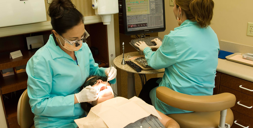 dr. britt and dental hygienist working on a patient